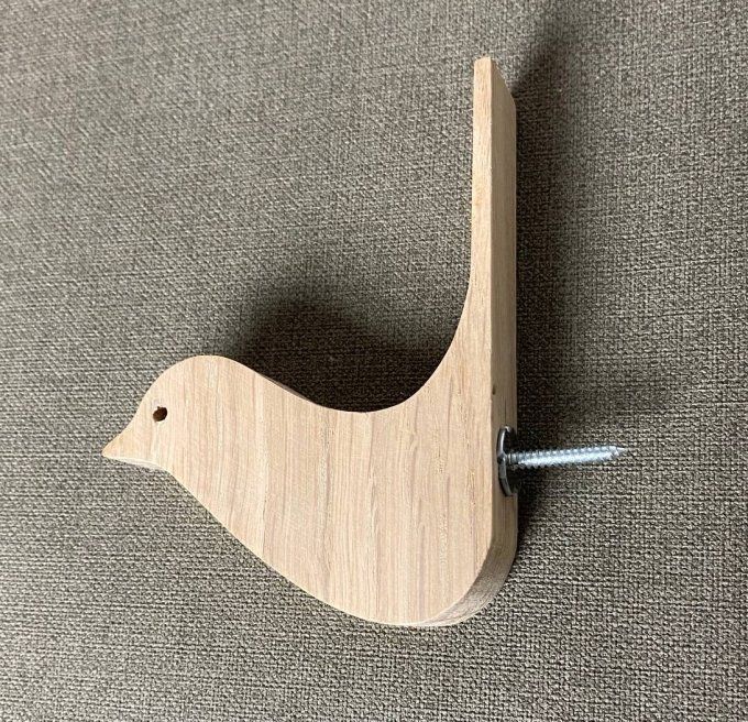 Une patère oiseau en bois en chêne massif.   