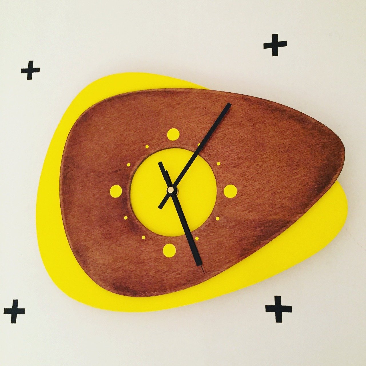 Horloge design en bois jaune.