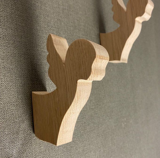 Une patère ange en bois en chêne massif.    