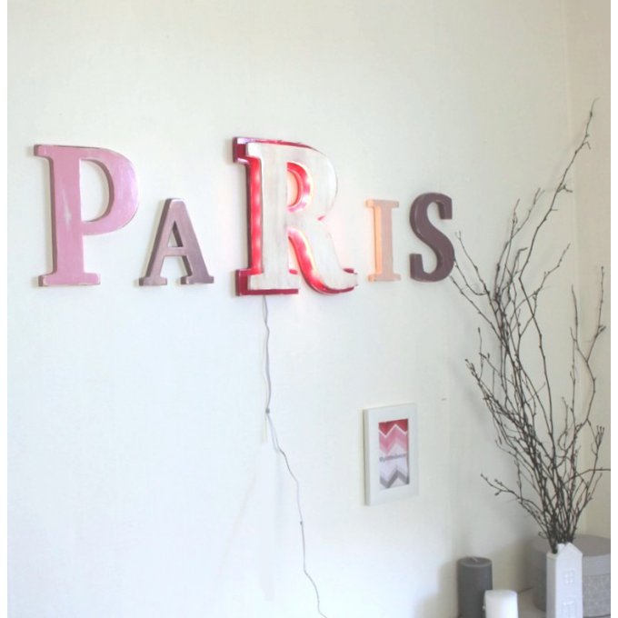 Mot géant avec une  lettre lumineuse PARIS tons roses.